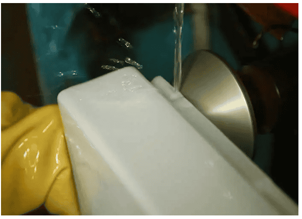 Close-up of glass lampshade being shaped in manufacturing process.