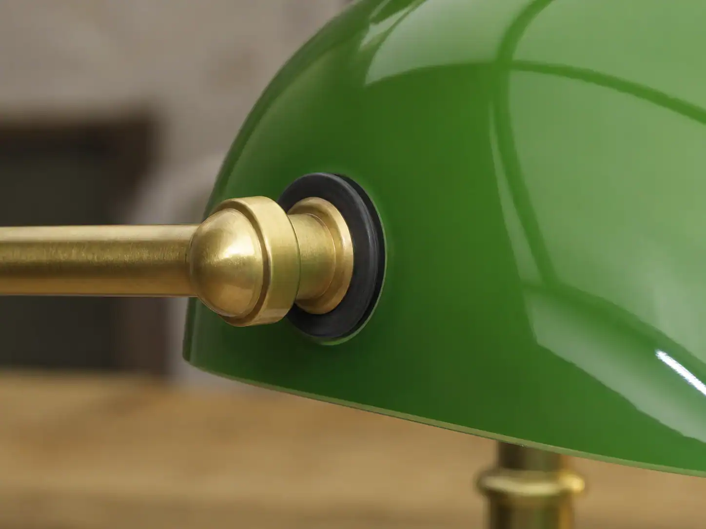 Close-up of a green glass lampshade with brass fitting for stylish lighting.