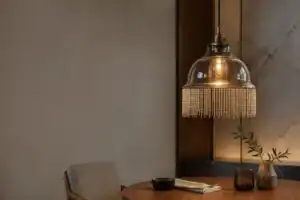 Elegant glass lampshade with fringe detail in modern interior setting.