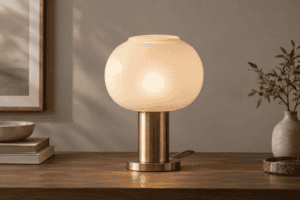 Paralume moderno in vetro con base in ottone su tavolo in legno.
