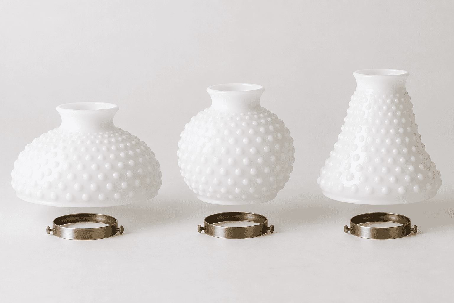 Set di tre paralumi in vetro bianco con superficie testurizzata per un'illuminazione elegante.