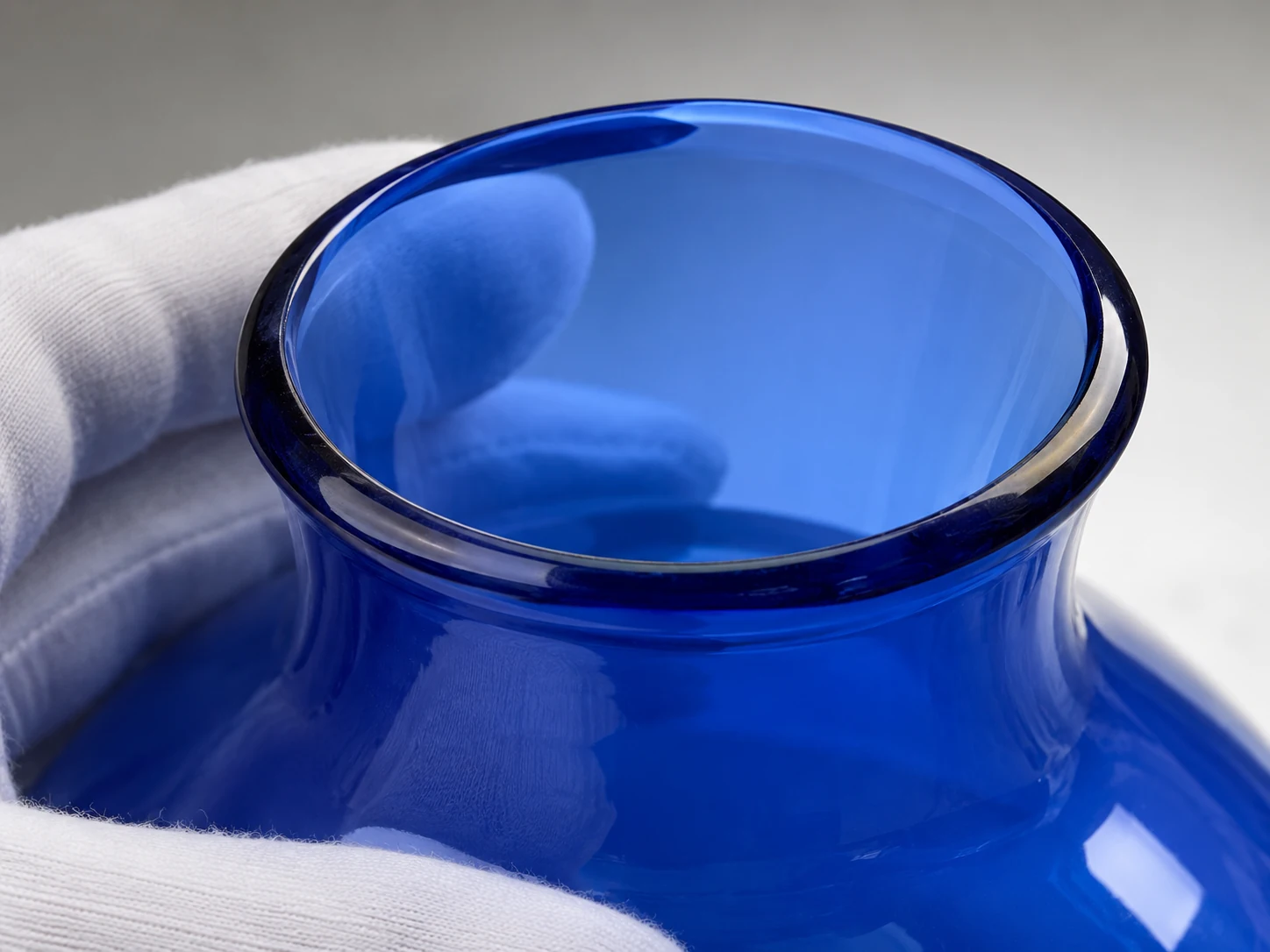 Close view of an open blue glass shade rim under a soft inspection light