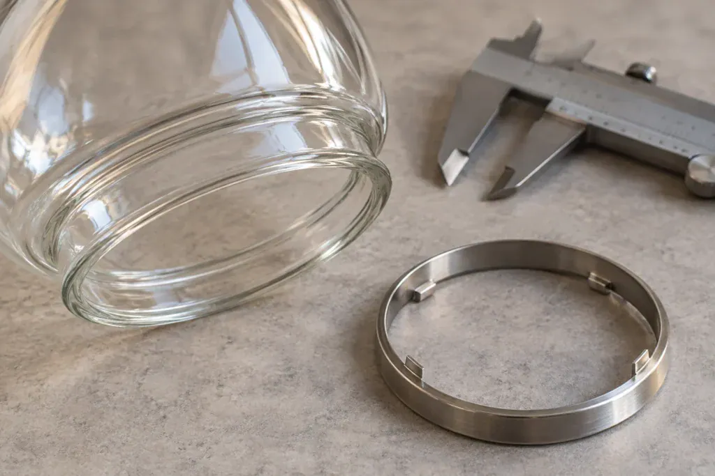 Glass shade rim and separate generic retaining ring beside a gauge